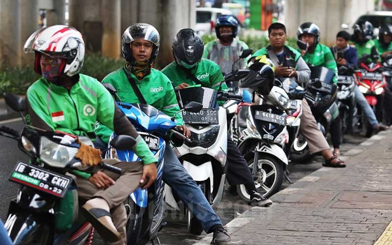 Pengemudi online sedang mengantri. Merger Grab-GoTo dipandang sebagai peluang memperkuat ekosistem digital ASEAN. Analis ini bantah pernyataan Wamenaker.