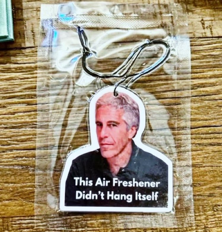 Gantungan mobil bergambar wajah Jeffrey Epstein dengan tulisan “This Air Freshener Didn’t Hang Itself”